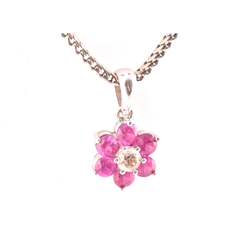 101 - An 18ct white gold, diamond, and ruby floral cluster pendant, centred with a round brilliant-cut dia... 