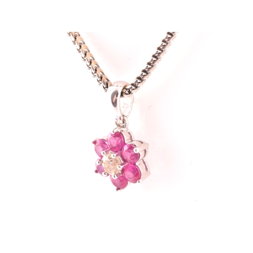 101 - An 18ct white gold, diamond, and ruby floral cluster pendant, centred with a round brilliant-cut dia... 