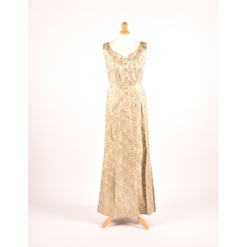 302 - A 1950s full length satin and silk dress embroidered with gold and green leaves on a silver grey gro... 