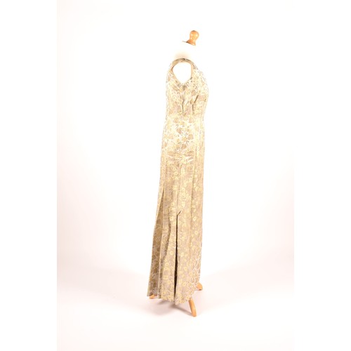 302 - A 1950s full length satin and silk dress embroidered with gold and green leaves on a silver grey gro... 