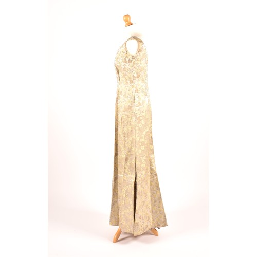 302 - A 1950s full length satin and silk dress embroidered with gold and green leaves on a silver grey gro... 