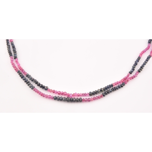 103 - A double strand necklace of faceted ruby and sapphire beads, approximately 45 cm long, fastened with... 