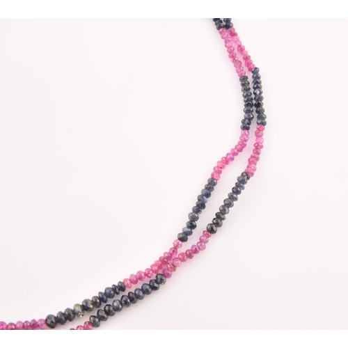 103 - A double strand necklace of faceted ruby and sapphire beads, approximately 45 cm long, fastened with... 