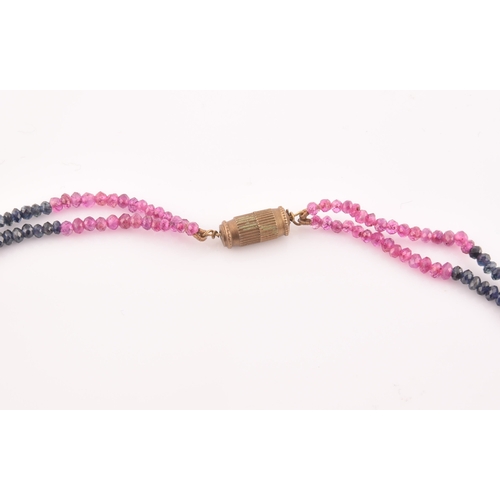 103 - A double strand necklace of faceted ruby and sapphire beads, approximately 45 cm long, fastened with... 