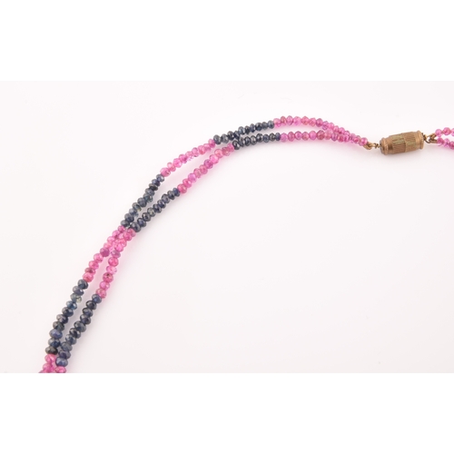 103 - A double strand necklace of faceted ruby and sapphire beads, approximately 45 cm long, fastened with... 