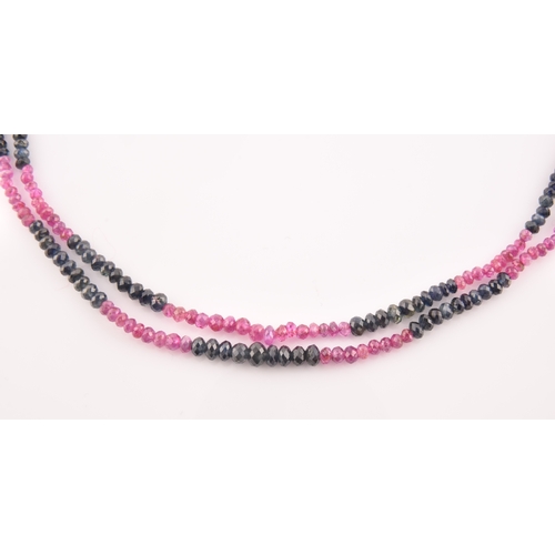 103 - A double strand necklace of faceted ruby and sapphire beads, approximately 45 cm long, fastened with... 