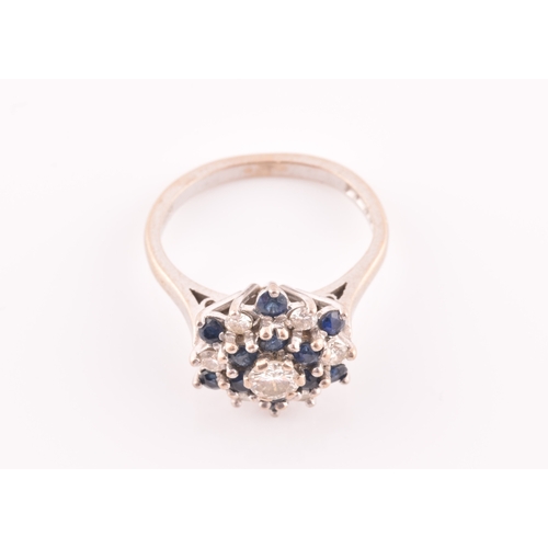 105 - An 18ct white gold, diamond, and sapphire cluster ring, centred with a round brilliant-cut diamond o... 