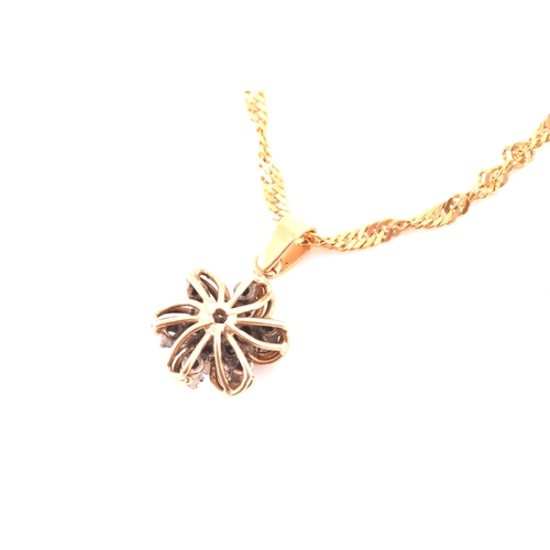 107 - A yellow metal and diamond floral diamond starburst pendant, set with thirteen round brilliant-cut d... 