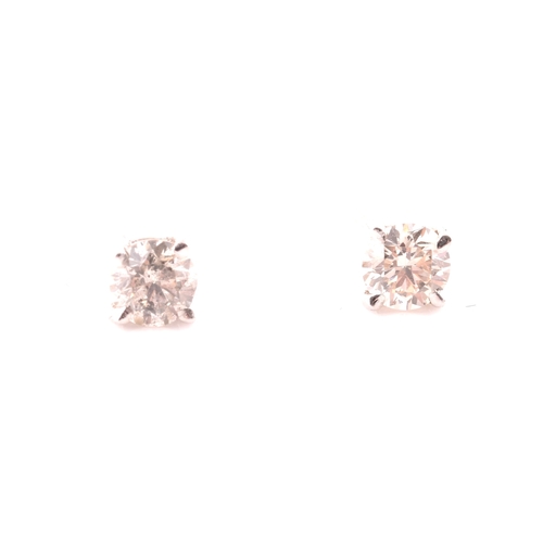 108 - A pair of 14ct white gold mounted solitaire diamond earrings, of approximately 0.30 carats combined.