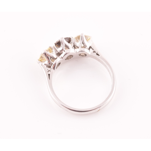 109 - An 18ct white gold and three stone diamond ring, centred with a pale fancy brown diamond flanked wit... 