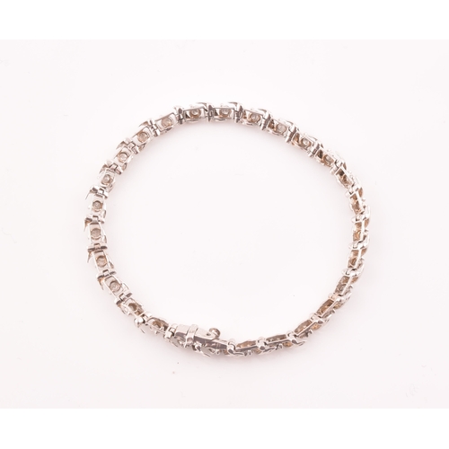 111 - A 14ct white gold and diamond line bracelet, the articulated links set with round brilliant-cut diam... 