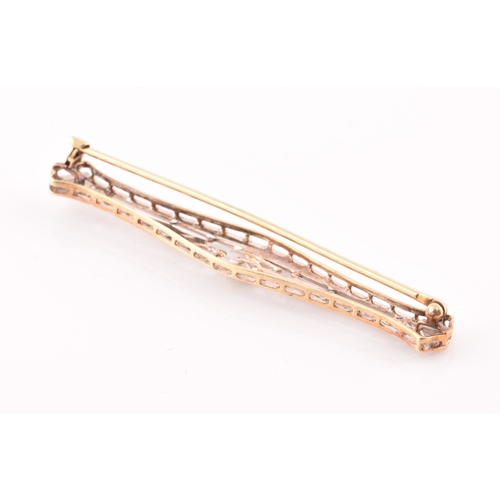 112 - A white and yellow metal bar brooch, in the Art Deco style, inset with a round brilliant-cut diamond... 