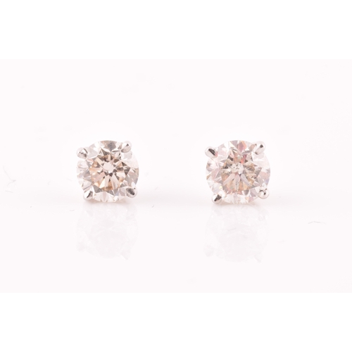 114 - A pair of 14ct white gold mounted solitaire diamond earrings, the diamonds of approximately 0.50 and... 