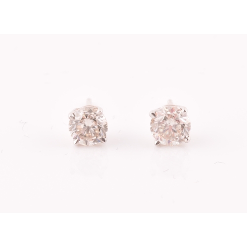 114 - A pair of 14ct white gold mounted solitaire diamond earrings, the diamonds of approximately 0.50 and... 