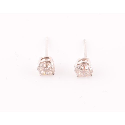 114 - A pair of 14ct white gold mounted solitaire diamond earrings, the diamonds of approximately 0.50 and... 