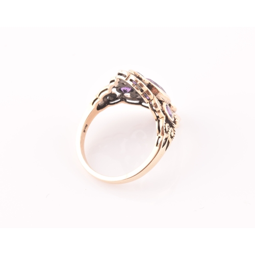 116 - A 9ct yellow gold and amethyst dress ring, the stylised openwork mount bezel set with a mixed oval-c... 