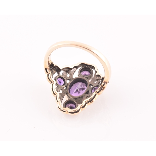 116 - A 9ct yellow gold and amethyst dress ring, the stylised openwork mount bezel set with a mixed oval-c... 