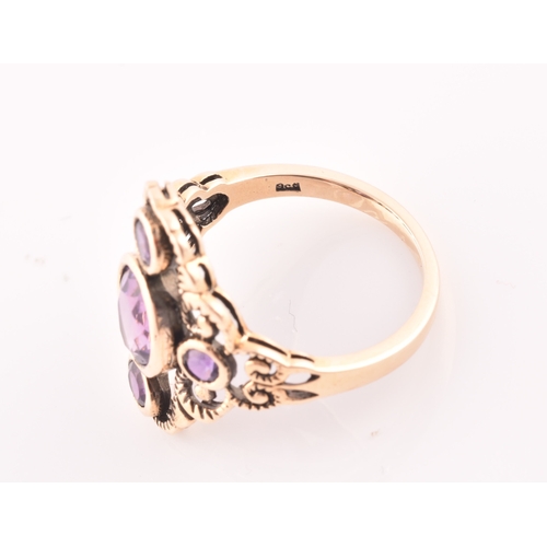 116 - A 9ct yellow gold and amethyst dress ring, the stylised openwork mount bezel set with a mixed oval-c... 