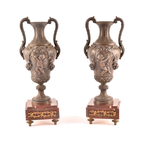 305 - A pair of Victorian spelter garniture urns, decorated with cherubs and garlands of flowers, with scr... 