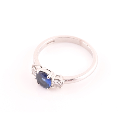 62 - An 18ct white gold, diamond, and sapphire ring, set with a mixed round-cut blue sapphire, flanked wi... 