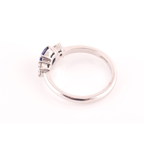 62 - An 18ct white gold, diamond, and sapphire ring, set with a mixed round-cut blue sapphire, flanked wi... 