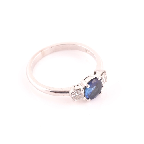 62 - An 18ct white gold, diamond, and sapphire ring, set with a mixed round-cut blue sapphire, flanked wi... 