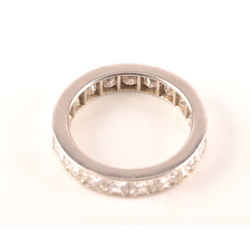 36 - A white metal diamond eternity ring, set with nineteen rectangular princess cut diamonds with an app... 