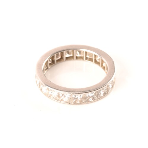 36 - A white metal diamond eternity ring, set with nineteen rectangular princess cut diamonds with an app... 