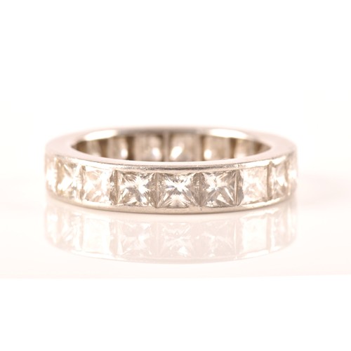 36 - A white metal diamond eternity ring, set with nineteen rectangular princess cut diamonds with an app... 