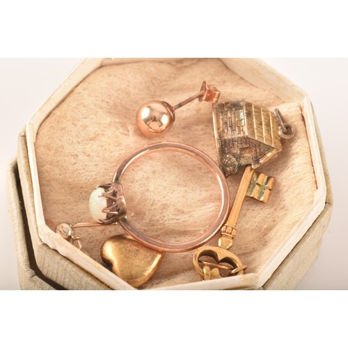 75 - A group of costume jewellery including a rose metal and opal ring, gold metal charms and studs, a pe... 