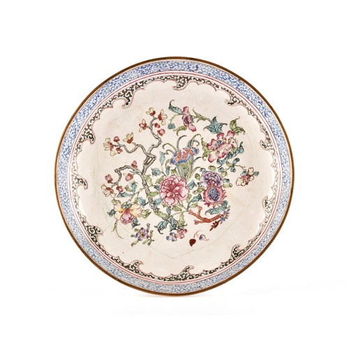 A Chinese Qianlong enamel charger, the central grounddecorated in famille rose colours with chrysanthemums and flowering branches, surrounded by a double border of waves and a band painted with coloured foliage. 22cm diameter.