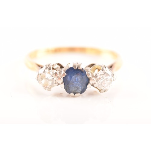 57 - An 18ct yellow gold three stone sapphire and diamond ring, set to centre with an oval sapphire with ... 