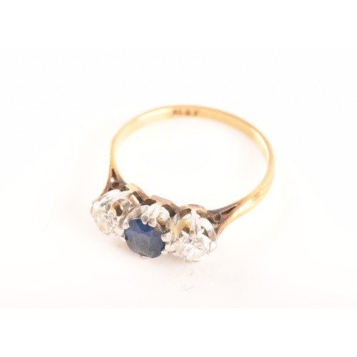 57 - An 18ct yellow gold three stone sapphire and diamond ring, set to centre with an oval sapphire with ... 