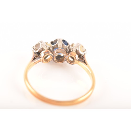 57 - An 18ct yellow gold three stone sapphire and diamond ring, set to centre with an oval sapphire with ... 