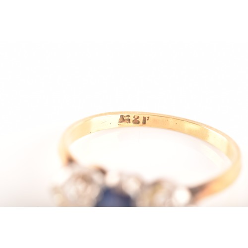 57 - An 18ct yellow gold three stone sapphire and diamond ring, set to centre with an oval sapphire with ... 