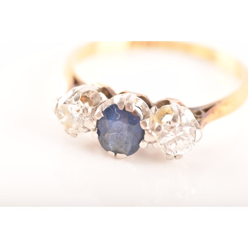 57 - An 18ct yellow gold three stone sapphire and diamond ring, set to centre with an oval sapphire with ... 