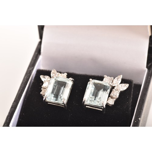 23 - A pair of 18ct white gold and platinum earrings, each featuring an octagonal step cut aquamarine wit... 