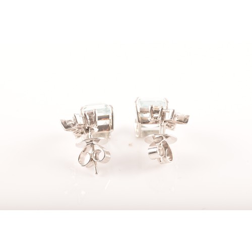 23 - A pair of 18ct white gold and platinum earrings, each featuring an octagonal step cut aquamarine wit... 