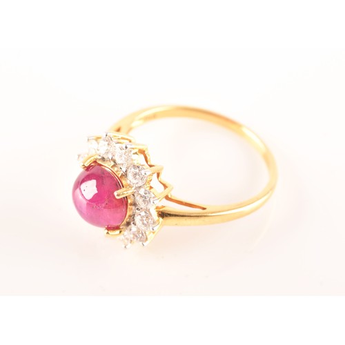 32 - A 18ct yellow gold cabochon ruby cluster ring, set with a central Burmese round cabochon ruby with a... 