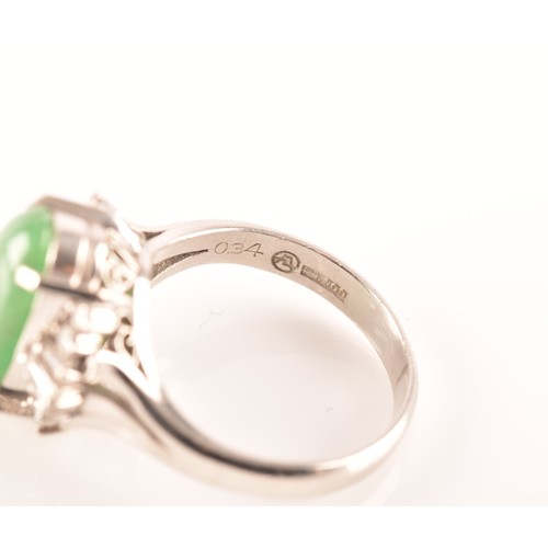 33 - A platinum ring set to centre with an elongated oval cabochon jade measuring approximately 14 x 7.2 ... 