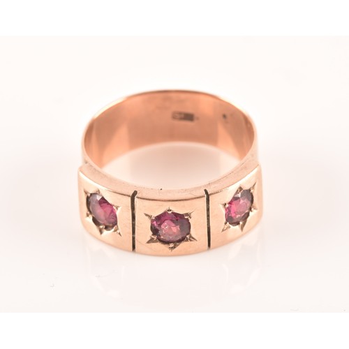 34 - A 9ct rose gold gypsy ring, featuring three almandine garnets with an approximate weight of 0.30 car... 