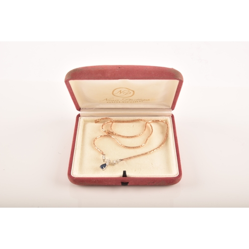 12 - A 14ct yellow gold sapphire and diamond necklace, featuring a pear cut sapphire with an approximate ... 