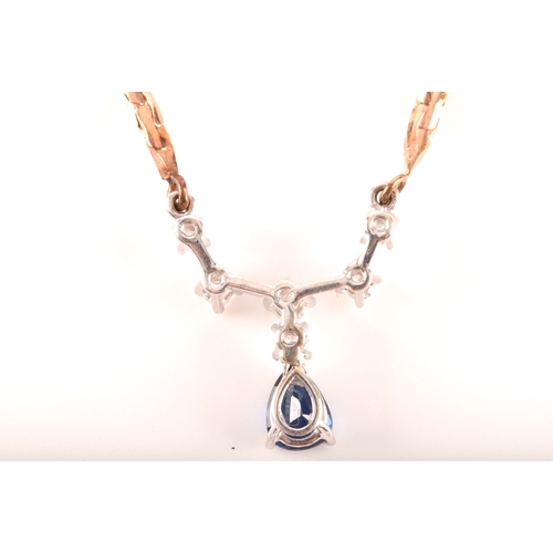 12 - A 14ct yellow gold sapphire and diamond necklace, featuring a pear cut sapphire with an approximate ... 