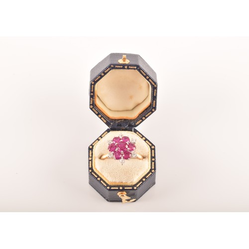 13 - A yellow and white metal synthetic ruby and diamond cluster ring, set to centre with a round ruby wi... 