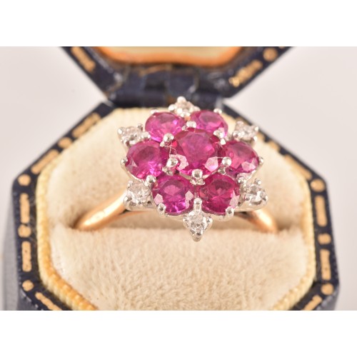 13 - A yellow and white metal synthetic ruby and diamond cluster ring, set to centre with a round ruby wi... 