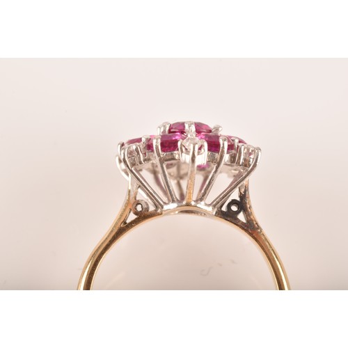 13 - A yellow and white metal synthetic ruby and diamond cluster ring, set to centre with a round ruby wi... 