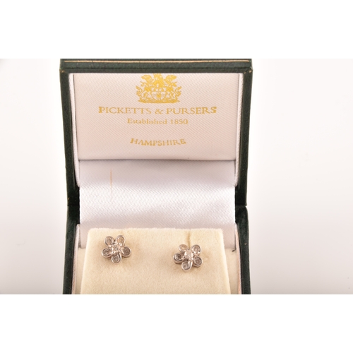 14 - A pair of 18ct white gold diamond set floral earrings, each set to centre with a brilliant cut diamo... 