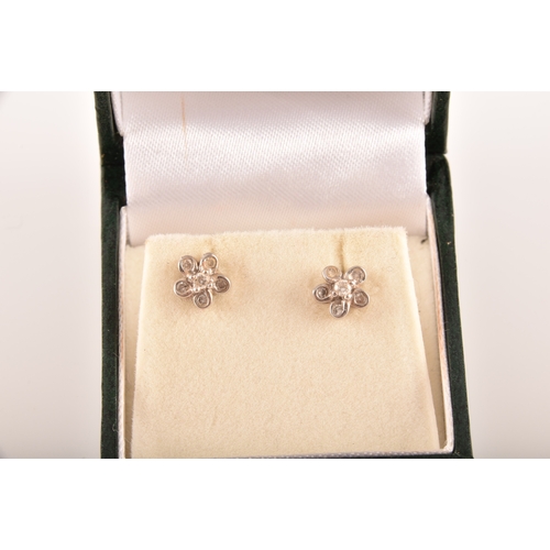 14 - A pair of 18ct white gold diamond set floral earrings, each set to centre with a brilliant cut diamo... 