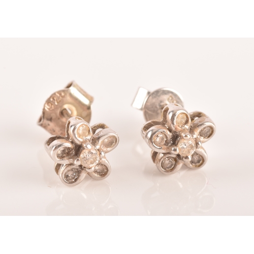 14 - A pair of 18ct white gold diamond set floral earrings, each set to centre with a brilliant cut diamo... 