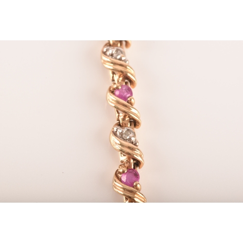 16 - A ruby and diamond 9ct yellow gold line bracelet, set with sixteen round rubies with a combined appr... 